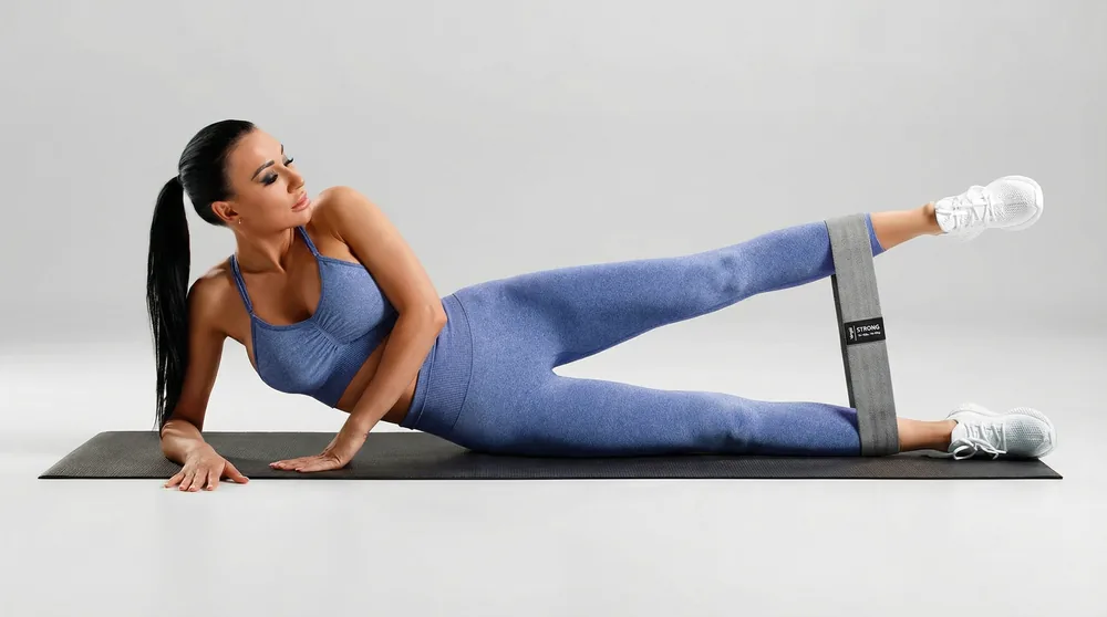 Lying on one side with the band around the ankles, lifting the top leg